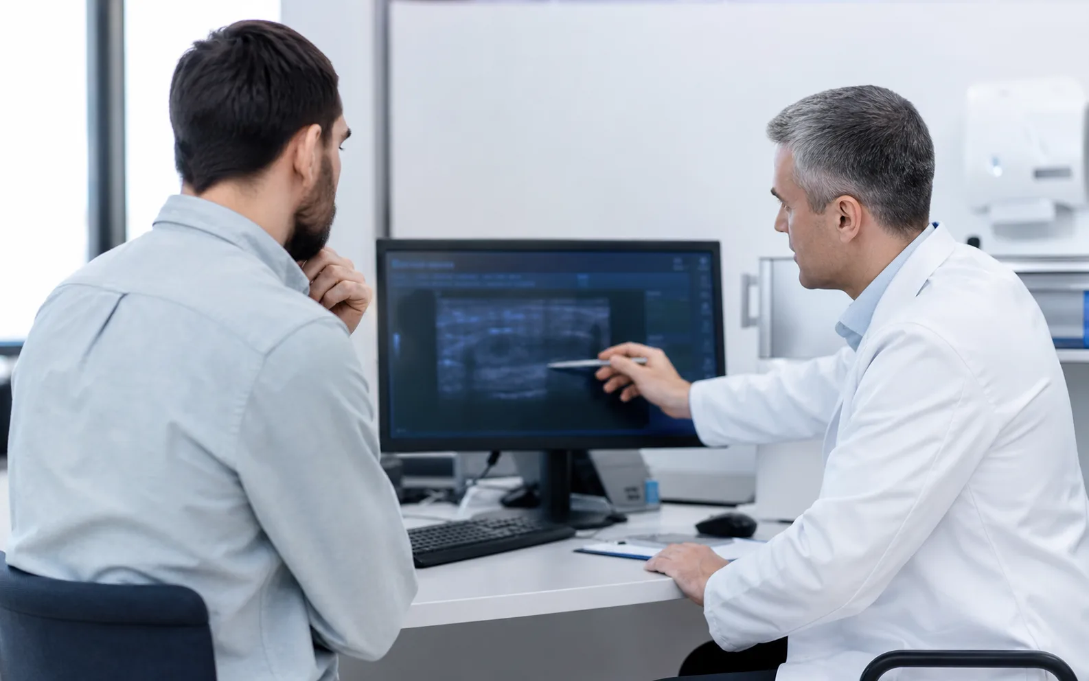 Urolog omawia z dorosłym pacjentem kwestie diagnostyczne.